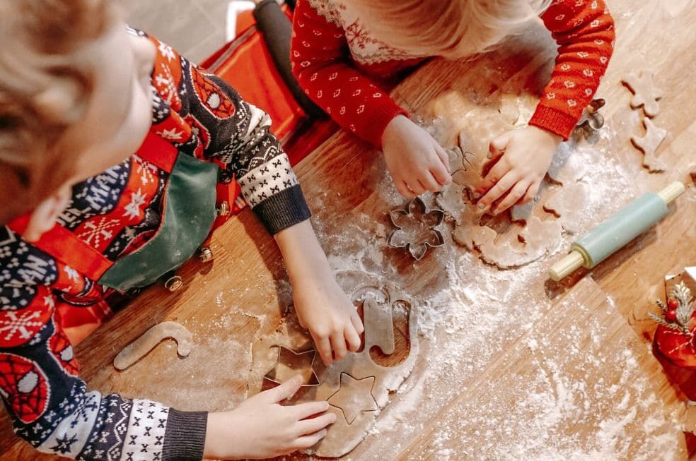 dzieci wykrawające pierniczki na stolnicy