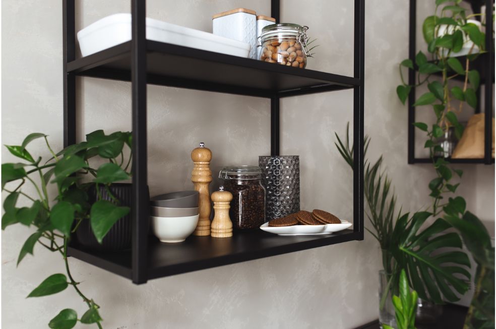 czarna półka ścienna z metalu na szarej ścianie z akcesoriami kuchennymi