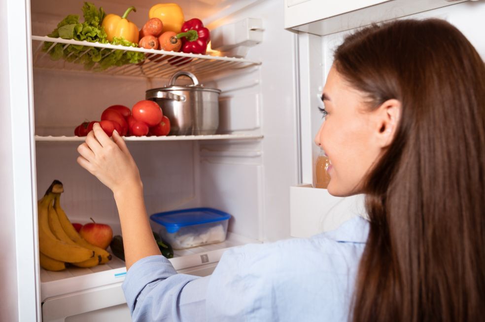 kobieta wyciągająca z lodów warzywa