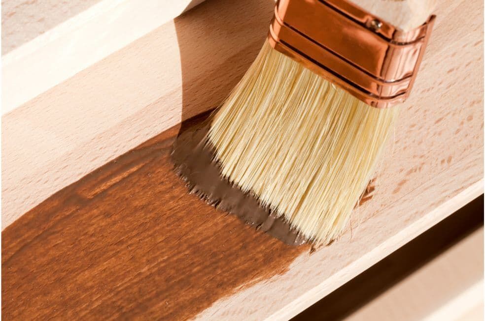 pędzel kryjący farbą brązową jasny kawałek drewna