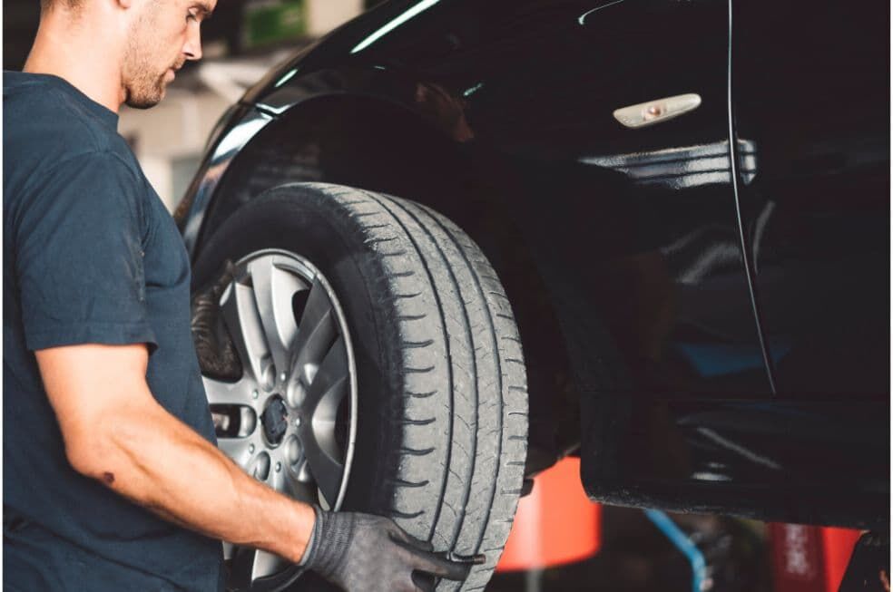 mężczyzna ściągająca koło samochodowe