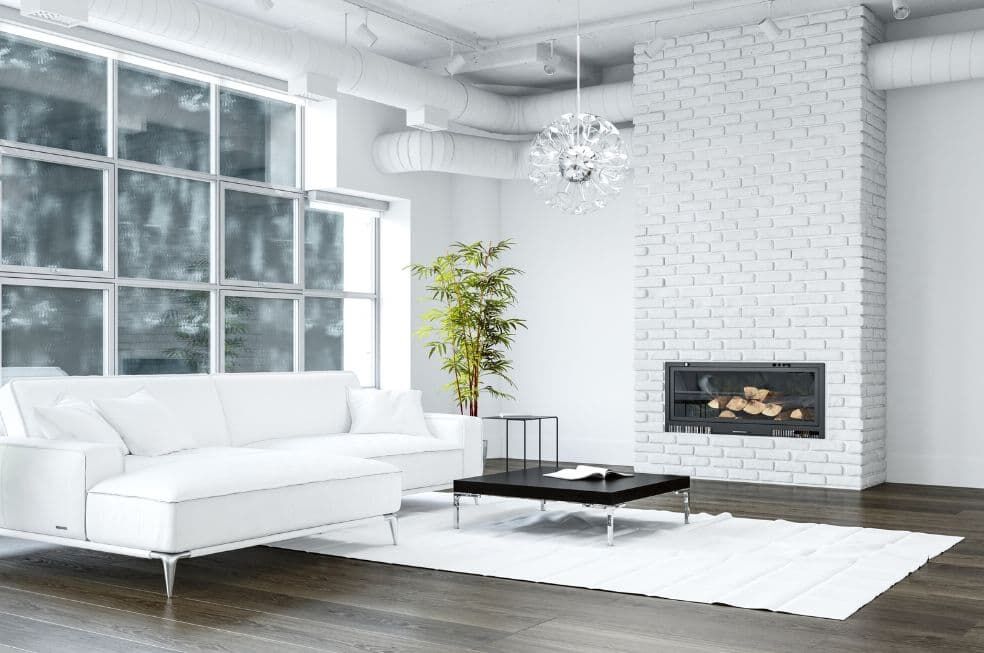 kominek obudowany białą cegłą w nowoczesnym salonie