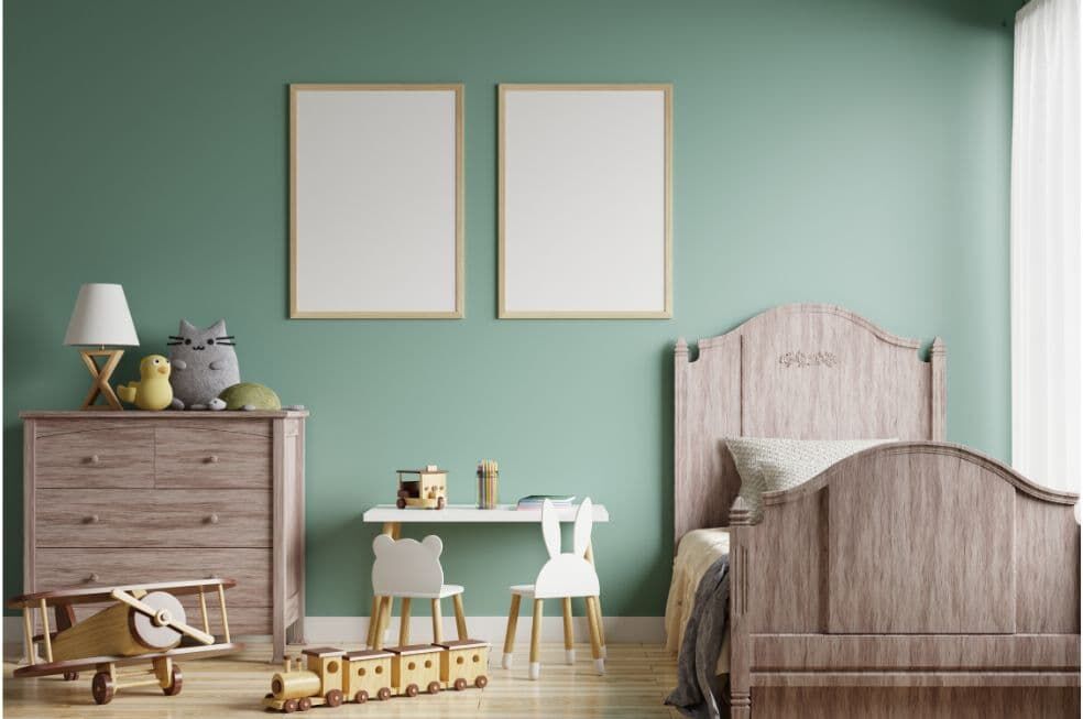 zielona ściana i drewniane meble w pokoju dziecięcym