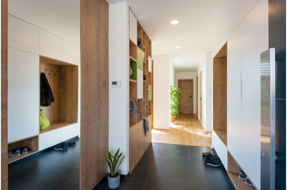 korytarz w mieszkaniu z drewnianymi meblami i ozdobnymi roślinami