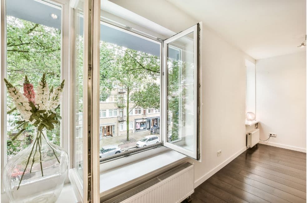 otwarte okno w mieszkaniu z widokiem na ulicę