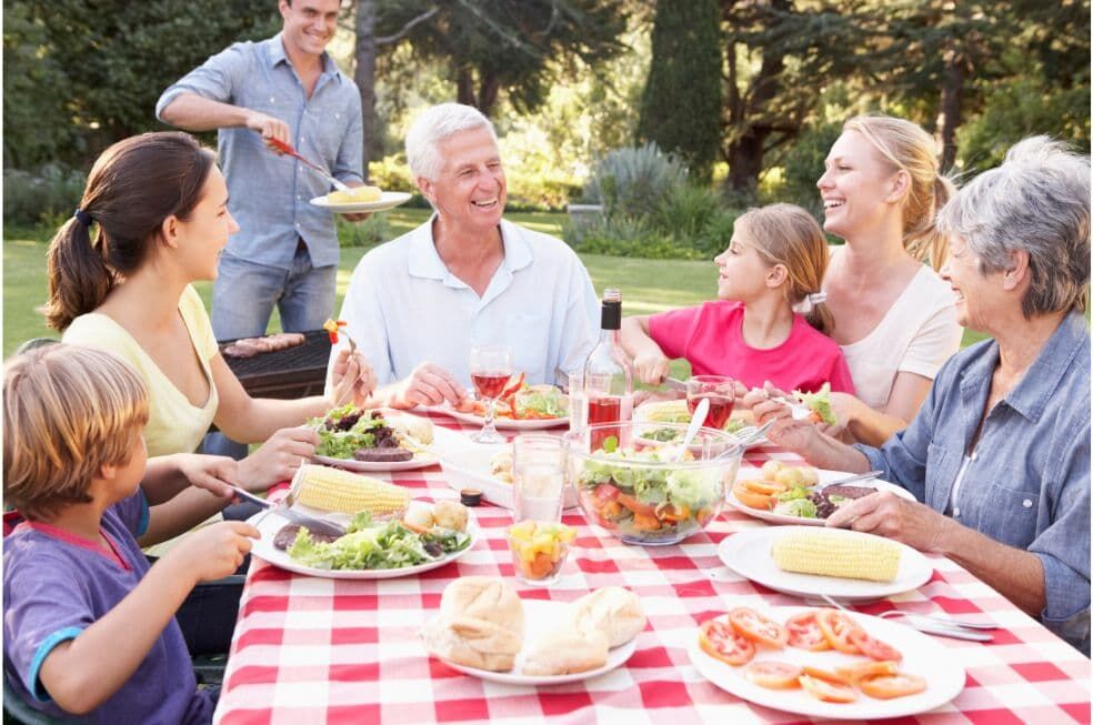 rodzina jedząca wspólnie posiłek na świeżym powietrzu