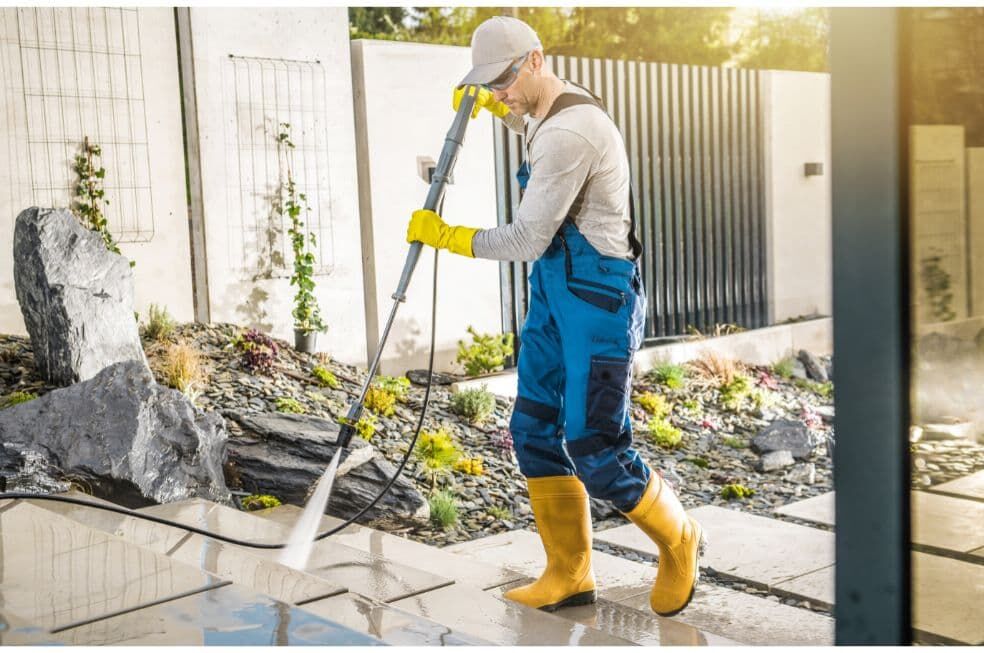 mężczyzna czyszczący schody betonowe przed domem