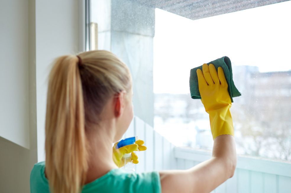 kobieta myjąca okno