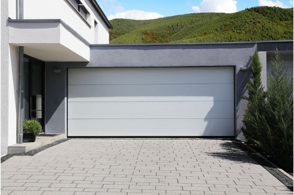 nowoczesny wjazd przed domem z szeroką bramą garażową