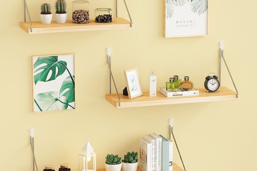 minimalistyczne półki drewniane na sznurkach na żółtej ścianie z dodatkami ozdobnymi