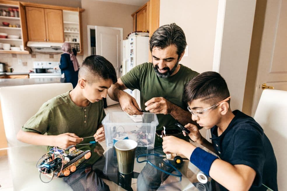 tata i synowie majsterkują w domu