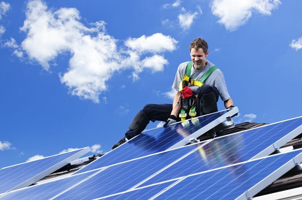 mężczyzna montujący panele słoneczne