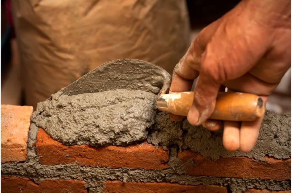 nakładanie cementu pomiędzy cegły