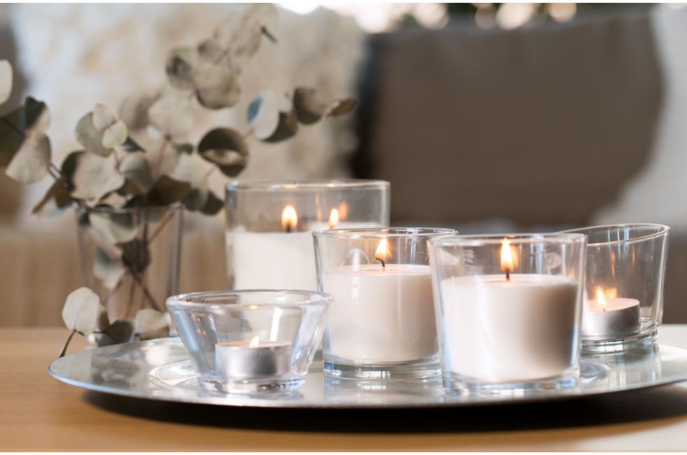 białe świeczki w małych słoiczkach na srebrnej tacy